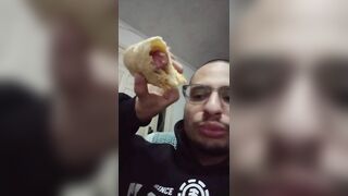 Garoto comendo um folhado de salsicha