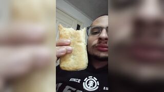 Garoto comendo um folhado de salsicha