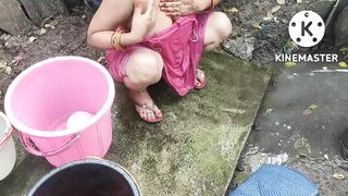 Indian house wife bathing outside