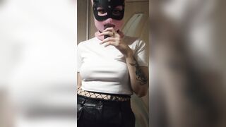 smoking girl in a pink balaclava and a cat mask