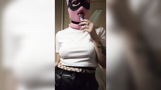 smoking girl in a pink balaclava and a cat mask