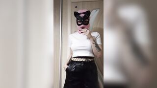 smoking girl in a pink balaclava and a cat mask